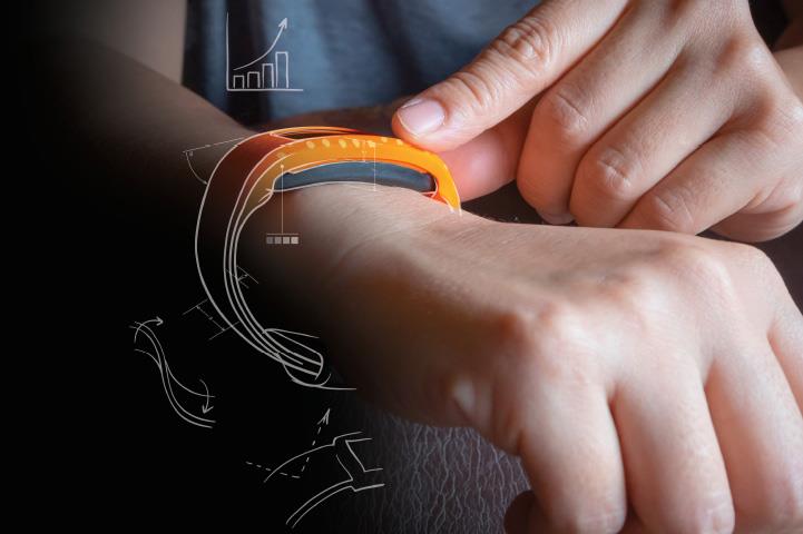 person wearing orange smart device with engineering notes
