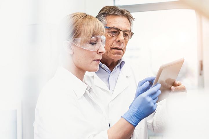 two chemists looking at guide