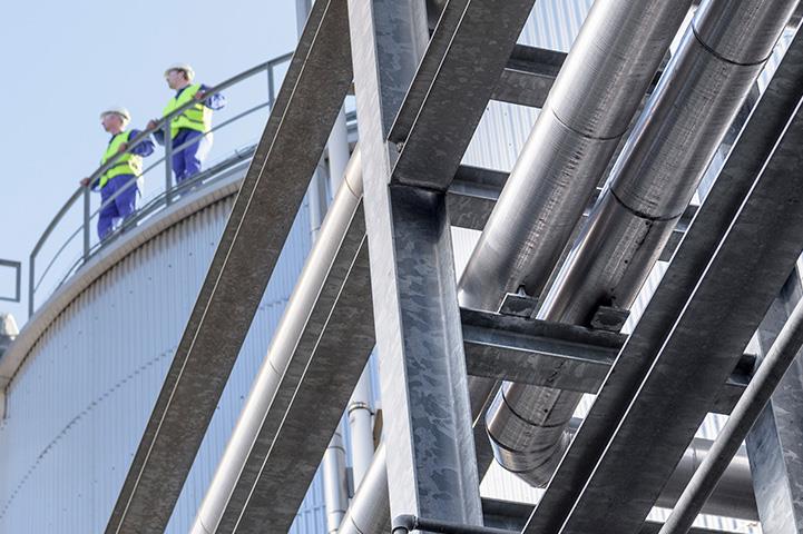two workers standing on oil storage