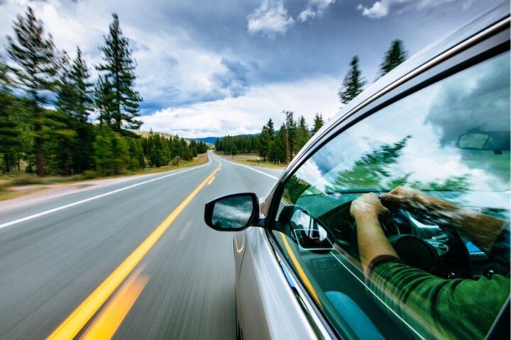 Driver on an open road with a clear sky, representing Viton™’s role in automotive efficiency and sustainability